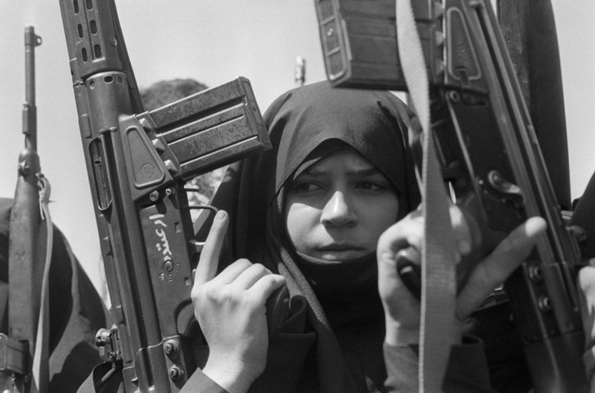 Una mujer sosteniendo un arma